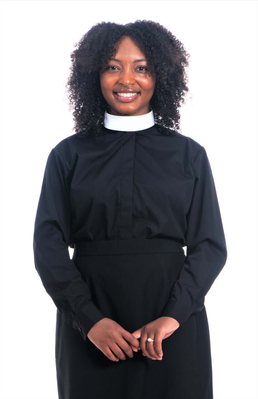 Ladies Banded Collar Clergy Shirt in Black worn by a smiling woman with curly hair.