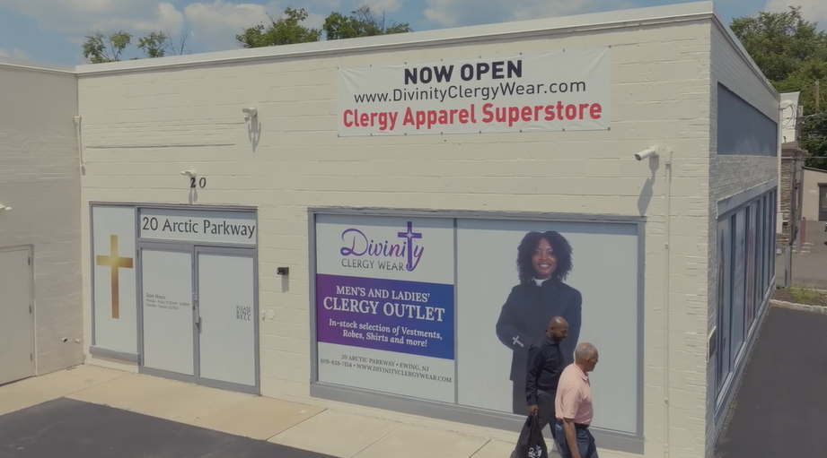 Exterior of Divinity Clergy Wear store, showcasing the grand opening sign for clergy apparel superstore.